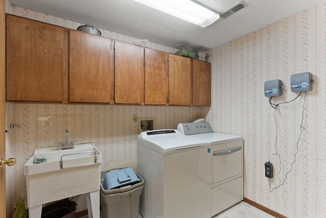 3827 E Funk Ave, Spokane, WA 99223 - washroom featuring cabinet space, separate washer and dryer, and wallpapered walls