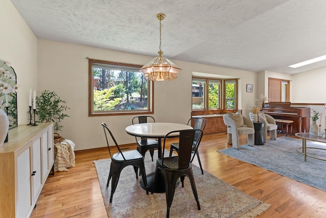 3827 E Funk Ave, Spokane, WA 99223 - dining area featuring a textured ceiling, light wood-style flooring, a chandelier, and plenty of natural light