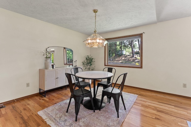 3827 E Funk Ave, Spokane, WA 99223 - dining area with a chandelier, a textured ceiling, and light wood-style floors