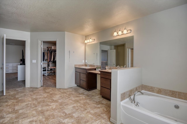 9502 N Awbrey Ct, Spokane, WA 99208 - bathroom with vanity, a garden tub, a spacious closet, and a textured ceiling
