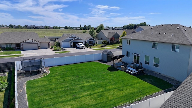 9502 N Awbrey Ct, Spokane, WA 99208 - fenced backyard with a trampoline, a residential view, driveway, a shed, and a garage