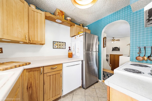 4511 N Stevenson Rd, Otis Orchards, WA 99027 - kitchen with wallpapered walls, white dishwasher, arched walkways, light countertops, and freestanding refrigerator