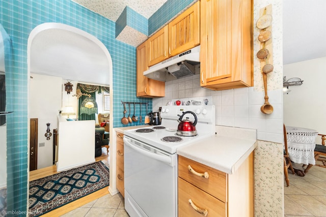 4511 N Stevenson Rd, Otis Orchards, WA 99027 - kitchen with electric range, under cabinet range hood, light tile patterned flooring, light countertops, and decorative backsplash