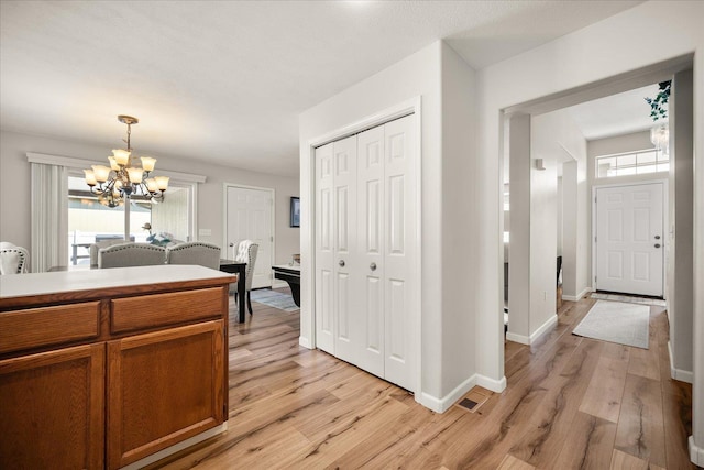 6310 W Sundance Dr, Spokane, WA 99208 - kitchen with a chandelier, light wood-style floors, brown cabinets, decorative light fixtures, and light countertops