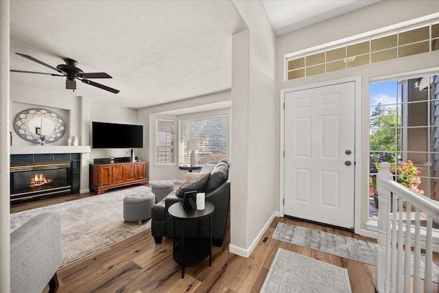 6310 W Sundance Dr, Spokane, WA 99208 - entryway featuring wood finished floors, a tiled fireplace, and ceiling fan