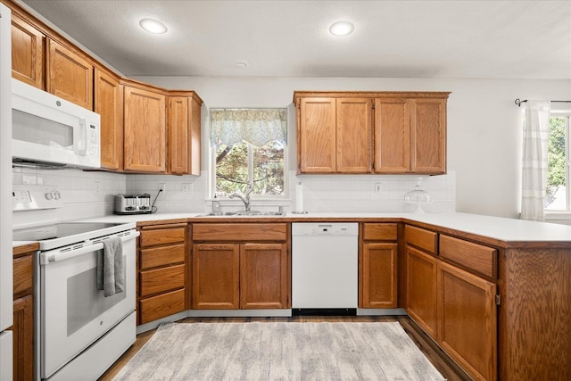 6310 W Sundance Dr, Spokane, WA 99208 - kitchen featuring white appliances, a peninsula, plenty of natural light, light countertops, and recessed lighting