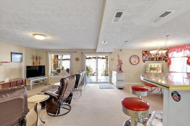 3930 N Deer Lake Rd, Loon Lake, WA 99148 - living room featuring carpet, plenty of natural light, a textured ceiling, and a chandelier