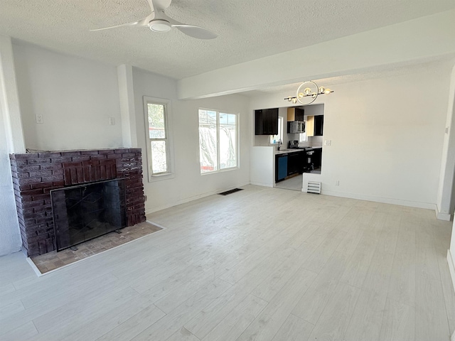 3012 E Wellesley Ave, Spokane, WA 99217 - unfurnished living room featuring a textured ceiling, a ceiling fan, light wood finished floors, and a fireplace