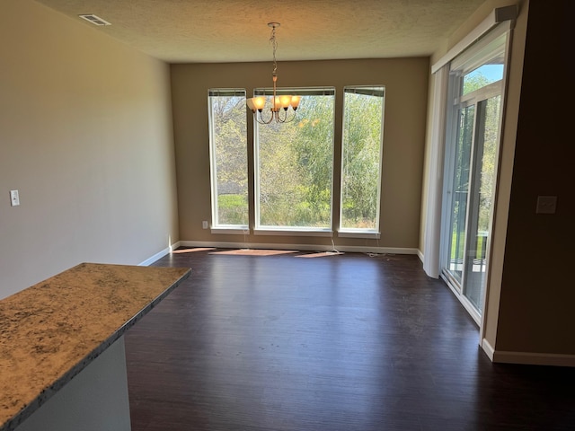 8516 N Summerhill Ln, Spokane, WA 99208 - unfurnished dining area featuring a chandelier, healthy amount of natural light, dark wood-type flooring, and a textured ceiling