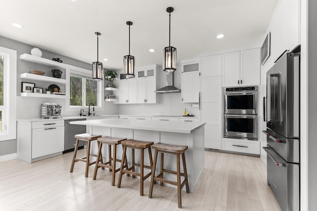 16215 W Coulee Hite Rd, Spokane, WA 99224 - kitchen featuring appliances with stainless steel finishes, open shelves, a kitchen island, light wood-type flooring, and white cabinetry