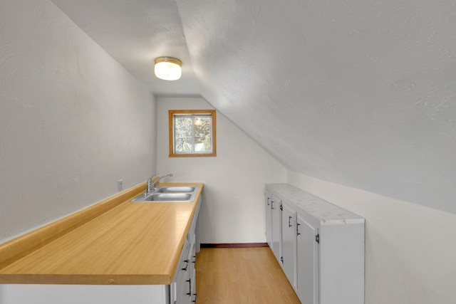 1407 E Broad Ave, Spokane, WA 99207 - kitchen featuring lofted ceiling, light wood finished floors, white cabinets, and light countertops