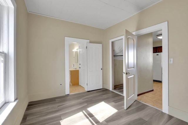1407 E Broad Ave, Spokane, WA 99207 - unfurnished bedroom featuring freestanding refrigerator, wood finished floors, a closet, and ensuite bathroom