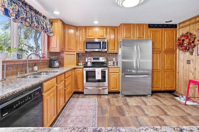 3425 E Upriver Dr, Spokane, WA 99217 - kitchen with appliances with stainless steel finishes, decorative backsplash, light stone countertops, wooden walls, and recessed lighting