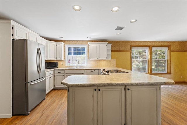 5245A W Prufer Crosscut Rd, Deer Park, WA 99006 - kitchen featuring freestanding refrigerator, a peninsula, black microwave, light wood-type flooring, and recessed lighting