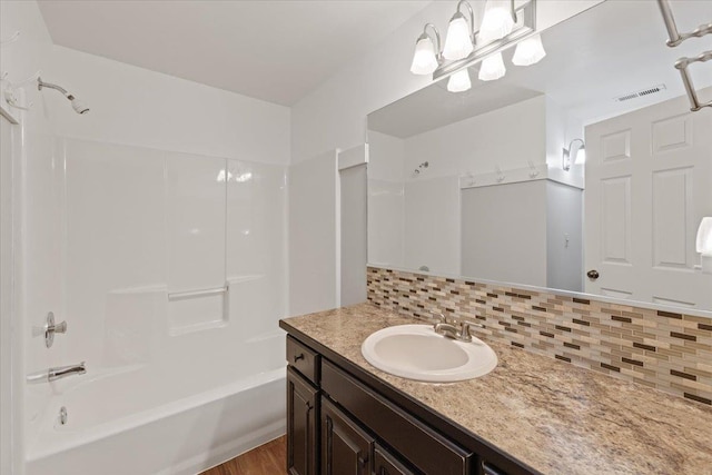 5245A W Prufer Crosscut Rd, Deer Park, WA 99006 - bathroom featuring vanity, shower / bathtub combination, decorative backsplash, and wood finished floors