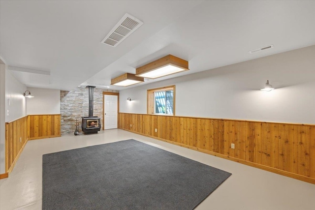 5245A W Prufer Crosscut Rd, Deer Park, WA 99006 - unfurnished living room featuring a wood stove, a wainscoted wall, and wooden walls