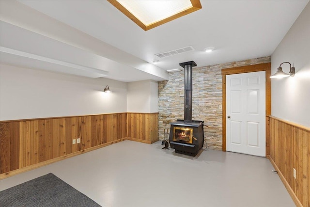5245A W Prufer Crosscut Rd, Deer Park, WA 99006 - basement featuring a wood stove, wooden walls, and wainscoting