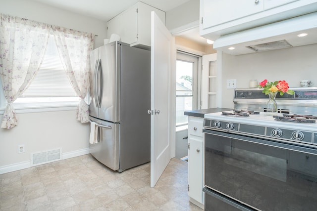 5224 N Post St, Spokane, WA 99204 - kitchen featuring range with gas cooktop, freestanding refrigerator, under cabinet range hood, white cabinetry, and light flooring