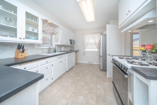 5224 N Post St, Spokane, WA 99204 - kitchen with appliances with stainless steel finishes, dark countertops, white cabinetry, decorative backsplash, and glass insert cabinets