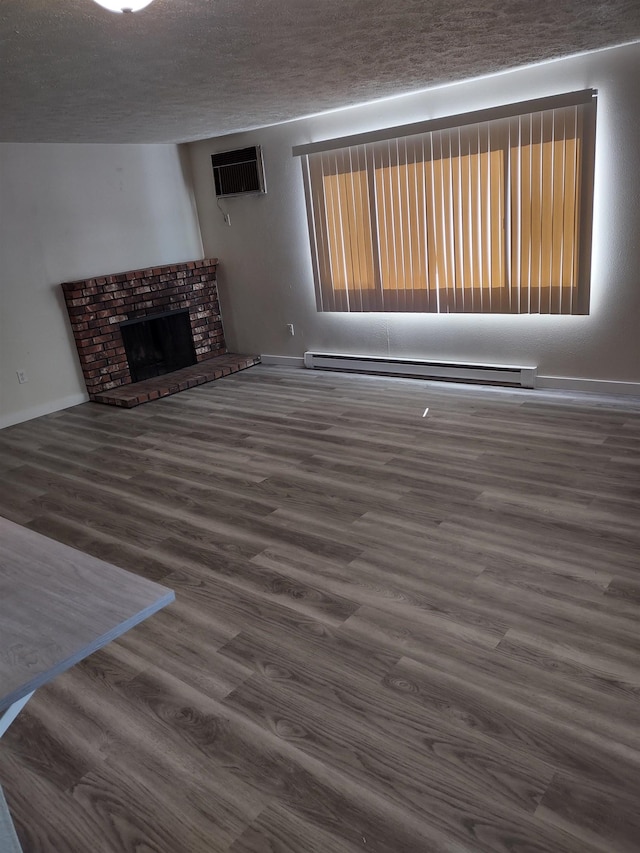 108 E Weile Ave # 1, Spokane, WA 99208 - unfurnished living room featuring a baseboard heating unit, wood finished floors, a wall mounted air conditioner, a textured ceiling, and a fireplace