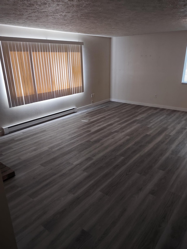 108 E Weile Ave # 1, Spokane, WA 99208 - empty room featuring baseboard heating, a textured ceiling, and dark wood-type flooring