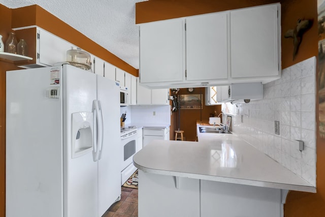 1401 W 1st St, Newport, WA 99156 - kitchen with white appliances, a peninsula, light countertops, decorative backsplash, and a textured ceiling