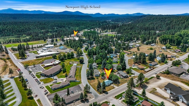 1401 W 1st St, Newport, WA 99156 - aerial view of property and surrounding area with a heavily wooded area and a mountainous background