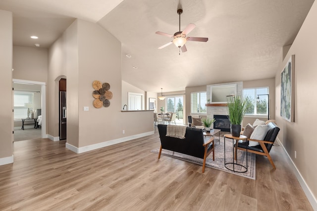 7014 E Columbia Dr, Spokane, WA 99217 - living area with arched walkways, a ceiling fan, plenty of natural light, a glass covered fireplace, and high vaulted ceiling