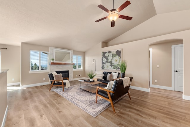 7014 E Columbia Dr, Spokane, WA 99217 - living area with arched walkways, lofted ceiling, a ceiling fan, light wood-style floors, and a fireplace