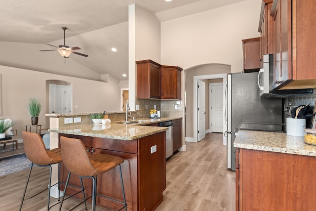7014 E Columbia Dr, Spokane, WA 99217 - kitchen with a peninsula, ceiling fan, backsplash, a breakfast bar, and arched walkways