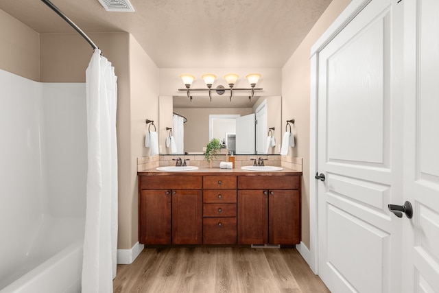 7014 E Columbia Dr, Spokane, WA 99217 - bathroom featuring wood finished floors, double vanity, and shower / bath combo with shower curtain