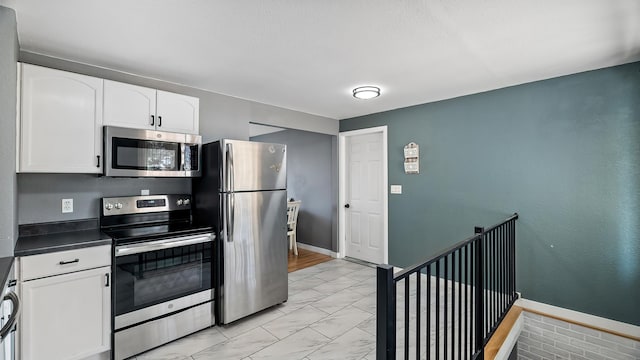 6121 N Belt St, Spokane, WA 99205 - kitchen featuring appliances with stainless steel finishes, light marble finish flooring, white cabinets, and dark countertops