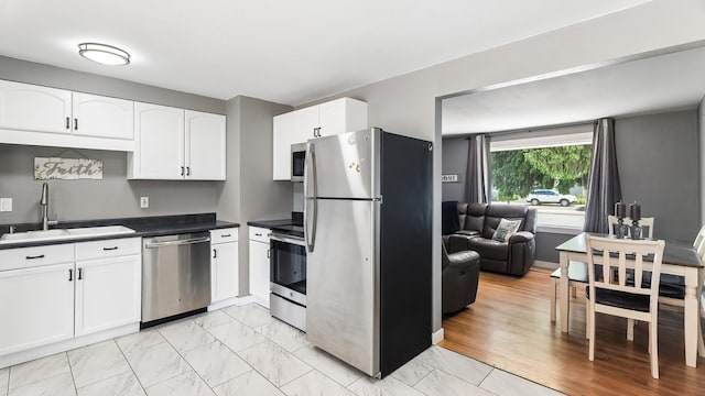 6121 N Belt St, Spokane, WA 99205 - kitchen featuring stainless steel appliances, white cabinetry, dark countertops, and light marble finish flooring