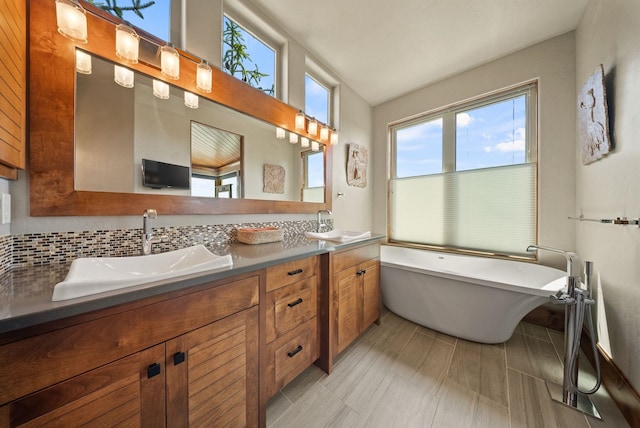14210 N Wandermere Estates Ln, Spokane, WA 99208 - bathroom featuring plenty of natural light, double vanity, a freestanding bath, and decorative backsplash