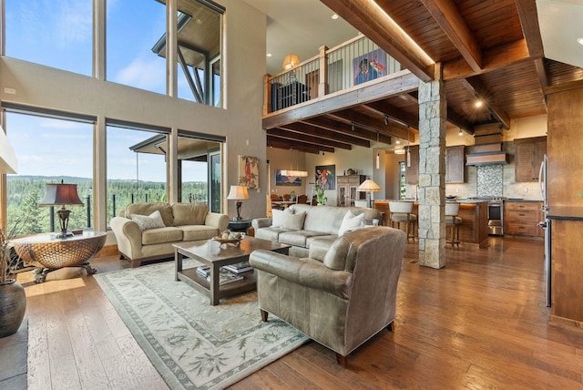 14210 N Wandermere Estates Ln, Spokane, WA 99208 - living room featuring dark wood-style flooring, ornate columns, a wooden ceiling with exposed beams, and a towering ceiling