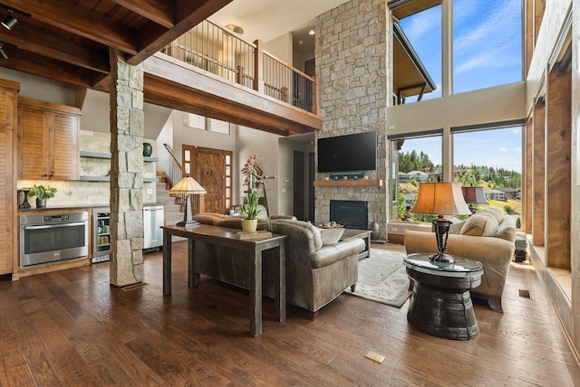 14210 N Wandermere Estates Ln, Spokane, WA 99208 - living area featuring a towering ceiling, dark wood-style floors, a fireplace, beverage cooler, and a wood ceiling with exposed beams