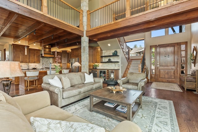 14210 N Wandermere Estates Ln, Spokane, WA 99208 - living area featuring ornate columns, a high ceiling, dark wood-style flooring, stairs, and beamed ceiling