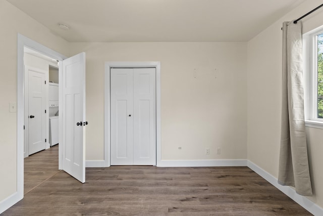 10124 N Wellen Ln, Spokane, WA 99218 - unfurnished bedroom featuring stacked washer / dryer, wood finished floors, and a closet