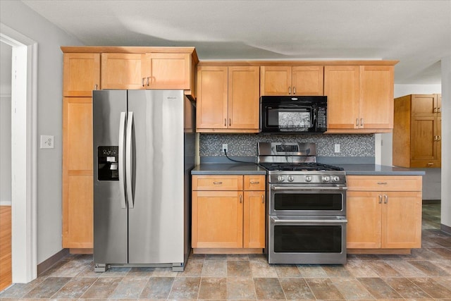 2828 S Arthur St, Spokane, WA 99203 - kitchen featuring stainless steel appliances, dark countertops, tasteful backsplash, and stone finish floors