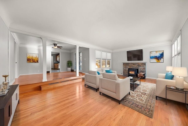 2828 S Arthur St, Spokane, WA 99203 - living room featuring a fireplace, light wood-type flooring, decorative columns, and a ceiling fan