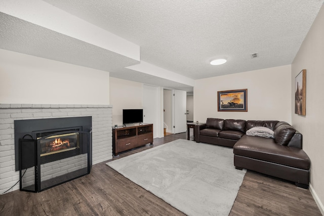 11912 N Atlantic St, Spokane, WA 99218 - living area featuring dark wood-style floors, a textured ceiling, and a fireplace