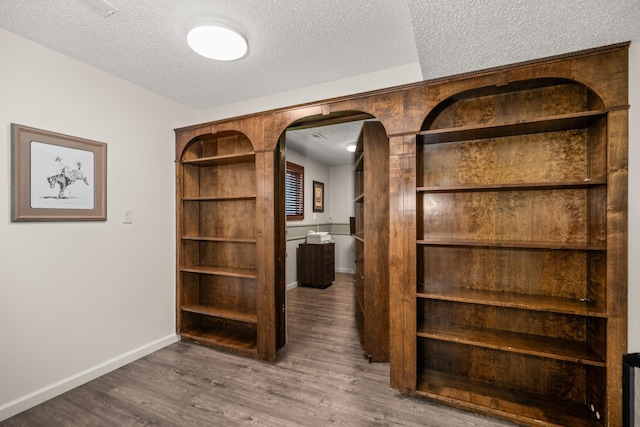 11912 N Atlantic St, Spokane, WA 99218 - hall featuring a textured ceiling, wood finished floors, and arched walkways