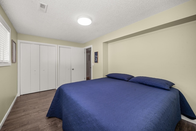 11912 N Atlantic St, Spokane, WA 99218 - bedroom with wood finished floors, multiple closets, and a textured ceiling