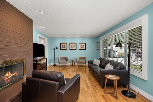 11912 N Atlantic St, Spokane, WA 99218 - living room featuring light wood-style flooring, a textured ceiling, and a fireplace