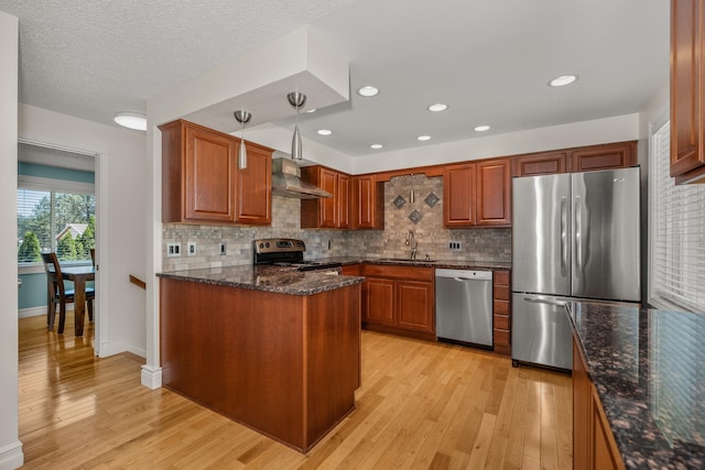 11912 N Atlantic St, Spokane, WA 99218 - kitchen with appliances with stainless steel finishes, wall chimney exhaust hood, light wood finished floors, tasteful backsplash, and recessed lighting