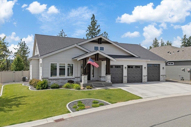 12918 E San Juan Ln, Spokane, WA 99206 - craftsman-style home featuring stone siding, a garage, concrete driveway, a gate, and a shingled roof