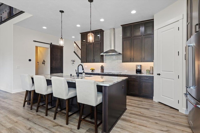 12918 E San Juan Ln, Spokane, WA 99206 - kitchen with wall chimney exhaust hood, high end refrigerator, light wood-type flooring, tasteful backsplash, and recessed lighting