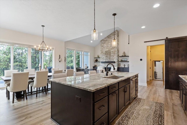 12918 E San Juan Ln, Spokane, WA 99206 - kitchen with dark brown cabinets, light wood-style flooring, a barn door, a fireplace, and recessed lighting