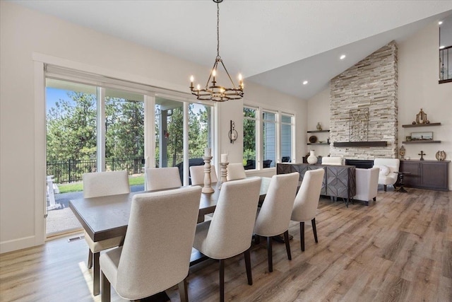 12918 E San Juan Ln, Spokane, WA 99206 - dining room with a chandelier, healthy amount of natural light, a fireplace, light wood-type flooring, and high vaulted ceiling
