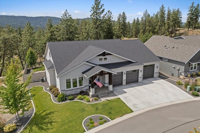 12918 E San Juan Ln, Spokane, WA 99206 - craftsman-style home with stone siding, driveway, a garage, roof with shingles, and a wooded view